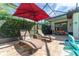 Screened-in pool with stone deck, lounge chairs, dining table and chairs and tropical landscaping at 14315 Rolling Dune Rd, Lithia, FL 33547