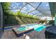 Aerial view of screened pool and spa with outdoor lounge area, surrounded by mature trees at 14315 Rolling Dune Rd, Lithia, FL 33547