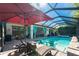 Sparkling screened-in pool with stone deck, lounge chairs and view of home with turquoise curtains at 14315 Rolling Dune Rd, Lithia, FL 33547
