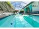 Screened pool featuring lounge chairs, a red umbrella, blue drapes, and a tiled pool deck at 14315 Rolling Dune Rd, Lithia, FL 33547