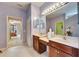 Bathroom with dual sink vanity, tile floor, a doorway view leading to a bedroom at 144 Silver Falls, Apollo Beach, FL 33572