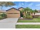 Charming single-Gathering home featuring a two-car garage, well-manicured lawn and lush tropical landscaping at 144 Silver Falls, Apollo Beach, FL 33572