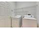 Convenient laundry room with washer, dryer, and storage shelves at 144 Silver Falls, Apollo Beach, FL 33572