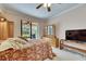 Comfortable main bedroom featuring a ceiling fan, wooden furniture, and a view of the screened patio at 144 Silver Falls, Apollo Beach, FL 33572