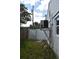 View of the home's side yard with white privacy fence and AC unit at 14640 Waterway Dr, Hudson, FL 34667