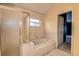 Bright bathroom featuring a soaking tub with tile surround and a glass-enclosed shower at 1610 Bondurant Way, Brandon, FL 33511