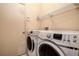 Bright laundry room featuring a modern washer and dryer set and convenient overhead shelving for storage at 1610 Bondurant Way, Brandon, FL 33511