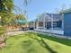 Spacious backyard featuring green artificial grass, an outdoor dining area, and partially covered porch at 1859 Oklahoma Ne Ave, St Petersburg, FL 33703