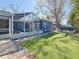 Spacious backyard showcasing the screened lanai, stone perimeter, and well-maintained artificial turf at 1859 Oklahoma Ne Ave, St Petersburg, FL 33703
