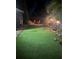 Backyard features an artificial turf lawn, elevated seating area, and vibrant plants, creating a relaxing and inviting outdoor space at 1859 Oklahoma Ne Ave, St Petersburg, FL 33703