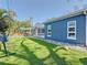 Side view of the house showcasing the artificial turf, screened lanai and the blue painted exterior at 1859 Oklahoma Ne Ave, St Petersburg, FL 33703