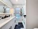 Modern bathroom with double vanity, sleek black fixtures, illuminated mirror, and glass-enclosed shower at 1859 Oklahoma Ne Ave, St Petersburg, FL 33703