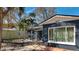 Blue home featuring large windows, palm trees, a detached garage, and tropical landscaping at 1859 Oklahoma Ne Ave, St Petersburg, FL 33703