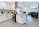 Well-lit kitchen with white cabinets, island, stainless steel appliances, and open view to the living area at 1859 Oklahoma Ne Ave, St Petersburg, FL 33703