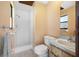 Well-lit bathroom featuring a walk-in shower with tiled walls, a modern toilet, and a vanity sink at 1906 Del Oro Ct, Dunedin, FL 34698
