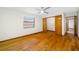 An inviting bedroom featuring hardwood floors, a window with blinds, and a closet for convenient storage at 1906 Del Oro Ct, Dunedin, FL 34698