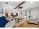 Open concept living room with hardwood floors connecting to the kitchen and a dining area at 1906 Del Oro Ct, Dunedin, FL 34698