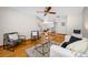 Cozy living room with hardwood floors, two chairs, a comfortable sofa, and views into the dining area at 1906 Del Oro Ct, Dunedin, FL 34698