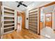 Office with custom built-in bookshelves, hardwood floors, and a view of the bathroom at 1906 Del Oro Ct, Dunedin, FL 34698