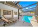 Relaxing lounge chairs by a screened-in pool offering a perfect spot for sunbathing and leisure at 1906 Del Oro Ct, Dunedin, FL 34698