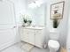 A bright bathroom features a vanity, toilet, tiled floor, and decor for a clean aesthetic at 19730 Preservation Woods Dr, Lutz, FL 33558