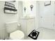 A clean bathroom features a toilet and vanity with a basket storage shelf and stylish wall decor at 19730 Preservation Woods Dr, Lutz, FL 33558