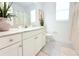 Bright bathroom features a vanity with marble countertop and white cabinets, complementing the gray tile floor at 19730 Preservation Woods Dr, Lutz, FL 33558