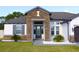 Charming home showcasing a stone facade and a decorative front door with elegant landscaping at 19730 Preservation Woods Dr, Lutz, FL 33558