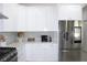 Close-up of modern kitchen area with stainless steel refrigerator and custom tile backsplash at 19730 Preservation Woods Dr, Lutz, FL 33558