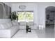 Bright living room with large sectional couch, decorative plant, and view of screened-in pool area at 19730 Preservation Woods Dr, Lutz, FL 33558