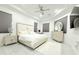 Bright main bedroom featuring tray ceiling, neutral decor, fan, and sitting area at 19730 Preservation Woods Dr, Lutz, FL 33558
