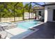 Sparkling screened-in pool and spa area, featuring an outdoor grill and a shed in the backyard at 19730 Preservation Woods Dr, Lutz, FL 33558