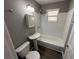 The bathroom has a white subway-tiled shower over tub, pedestal sink, and toilet at 203 D Street, Brooksville, FL 34601