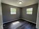 This bedroom features dark wood-look floors and large windows that provide ample natural light at 203 D Street, Brooksville, FL 34601