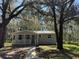 Quaint single story home with mature trees and a pathway leading to the entrance at 203 D Street, Brooksville, FL 34601