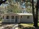 Charming single story home with a welcoming front porch and mature tree shading the property at 203 D Street, Brooksville, FL 34601