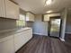 Modern kitchen features stainless steel appliances, new white cabinets and wood-look floors at 203 D Street, Brooksville, FL 34601
