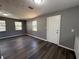 Open-concept living room with dark wood-look floors and natural light from multiple windows at 203 D Street, Brooksville, FL 34601