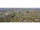 An aerial view showcasing a neighborhood with lush trees, green spaces, and views of water in the distance at 2213 Spanish Vistas Dr, Dunedin, FL 34698