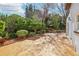 This backyard features garden beds, lush landscaping, and a concrete patio at 2213 Spanish Vistas Dr, Dunedin, FL 34698