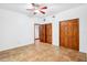 Spacious bedroom with ceiling fan, tiled floor, and double-door closet for storage at 2213 Spanish Vistas Dr, Dunedin, FL 34698