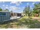 Large back yard featuring a screened in porch, stone seating, and large storage shed at 2908 E 99Th Ave, Tampa, FL 33612