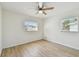 A bright bedroom features newly installed floors, a ceiling fan, and natural light from the windows at 2908 E 99Th Ave, Tampa, FL 33612