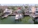 Aerial view of waterfront property with dock and boat, surrounded by tropical foliage at 300 16Th Ave, Indian Rocks Beach, FL 33785