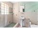 Bathroom featuring a tiled shower, pedestal sink, and a square glass block window at 300 16Th Ave, Indian Rocks Beach, FL 33785