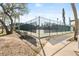 Outdoor tennis court surrounded by a dark green chainlink fence, offering a great space for recreational activities at 300 16Th Ave, Indian Rocks Beach, FL 33785