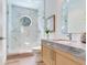 Modern bathroom with a stylish shower, a round window for natural light, and wood grain vanity at 3030 W Santiago St # 3, Tampa, FL 33629
