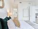 Inviting bedroom featuring comfortable bedding, soft lighting, and a view into the bathroom at 3030 W Santiago St # 3, Tampa, FL 33629
