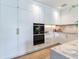 Modern kitchen with sleek white cabinetry, marble countertops, stainless steel appliances, and gold hardware at 3030 W Santiago St # 3, Tampa, FL 33629