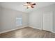 Neutral bedroom featuring wood-look floors, a ceiling fan, and a window with blinds at 3206 Hurley Grove Way, Valrico, FL 33596